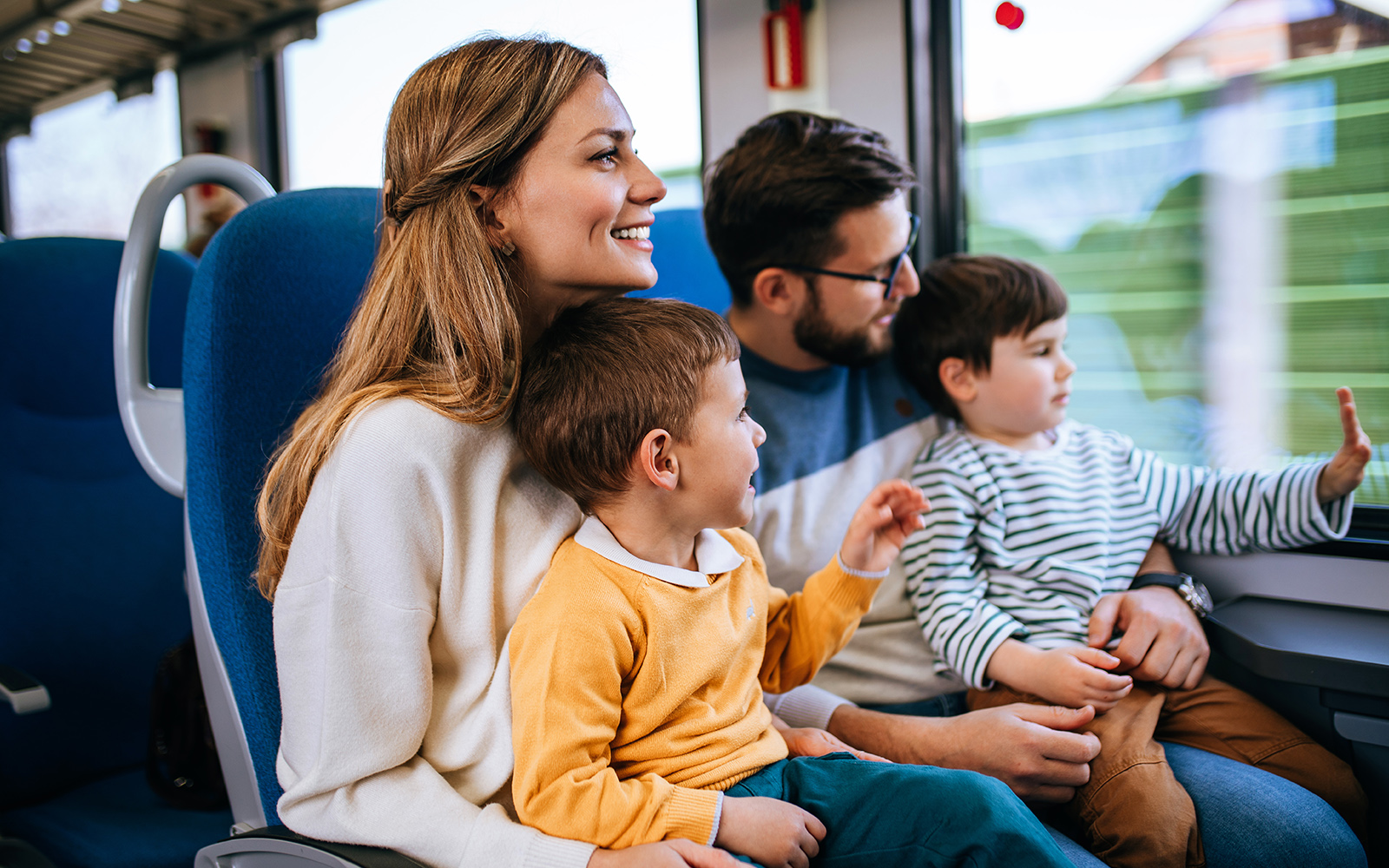 Family enjoying a scenic train journey during a coach transfer in Europe.
